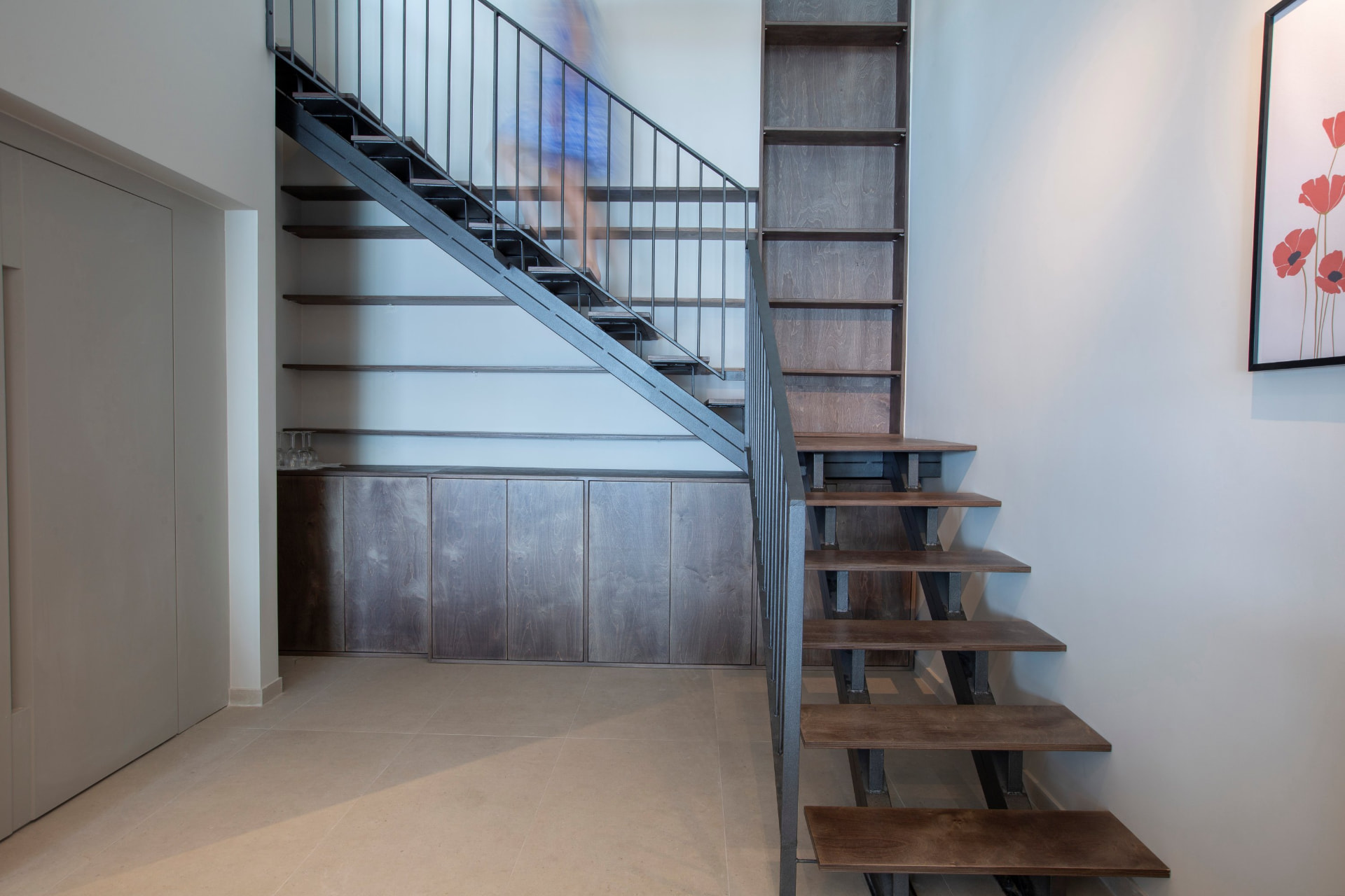 Entrance hallway with open timber and steel staircase and built-in shelving