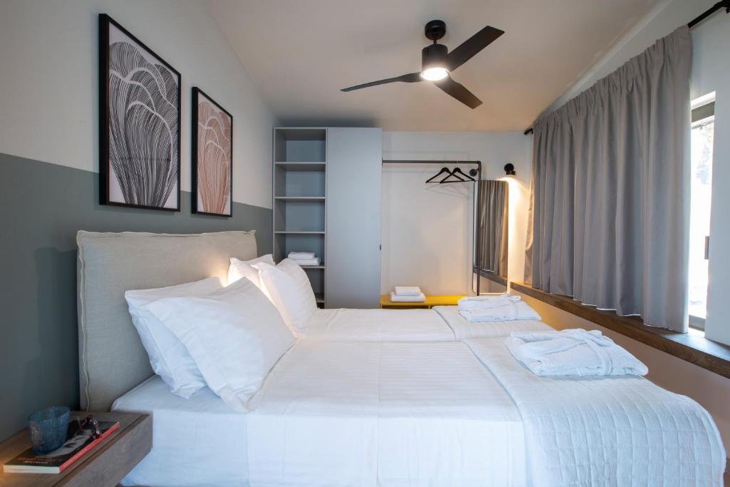 Bedroom with ceiling fan, sage green wall and framed botanical prints