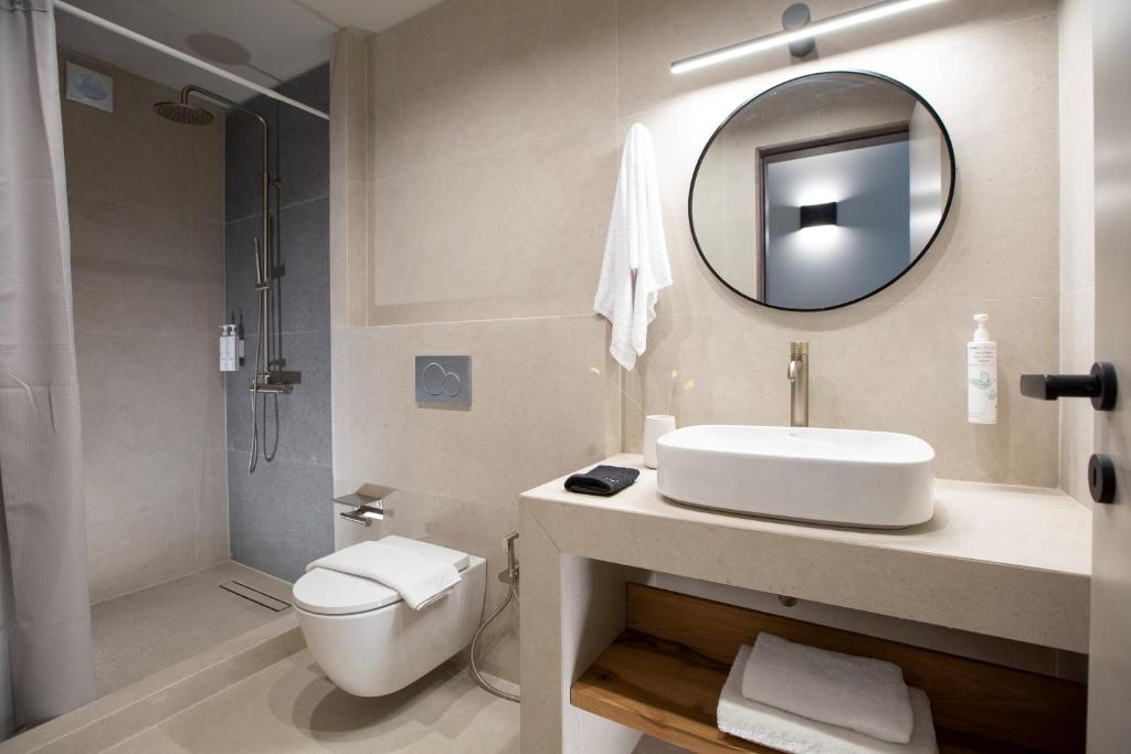 Bathroom with walk-in rain shower, round mirror and stone vanity