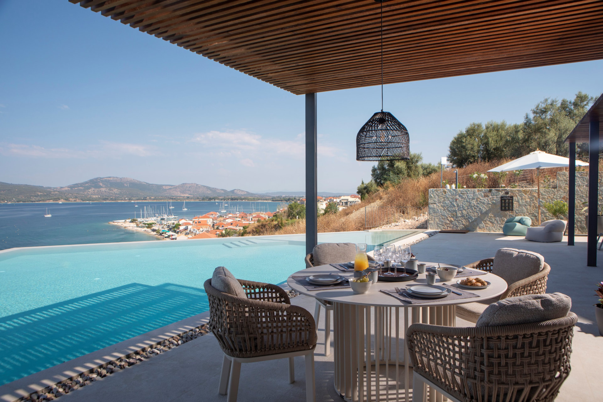 Poolside dining table set for breakfast overlooking Paleros marina