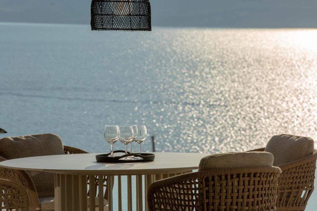 Outdoor table with wine glasses overlooking the shimmering sea