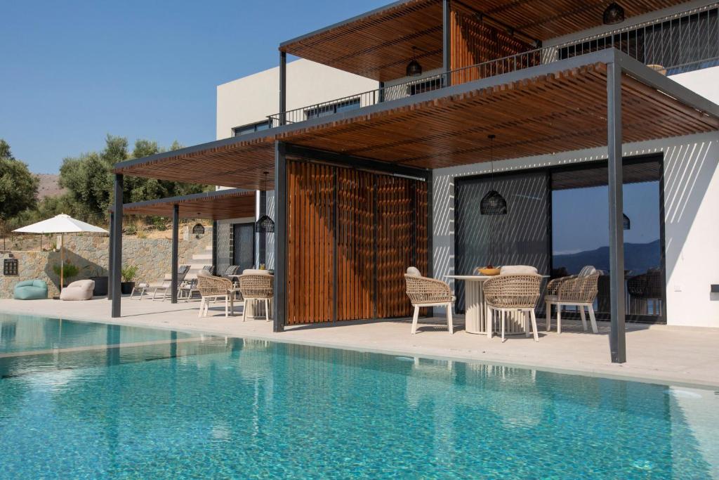 Villa facade and large pool with timber pergolas and olive groves