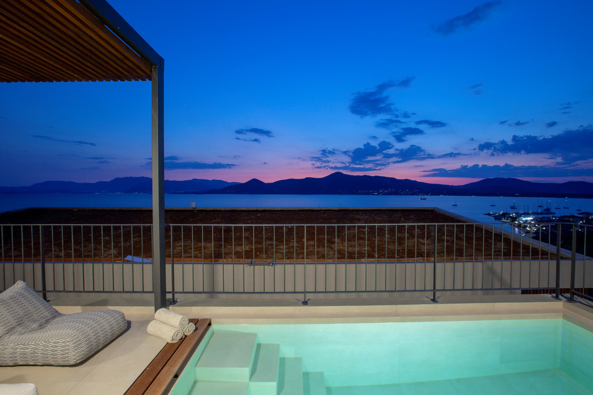 Plunge pool and lounger on the terrace at sunset over the bay