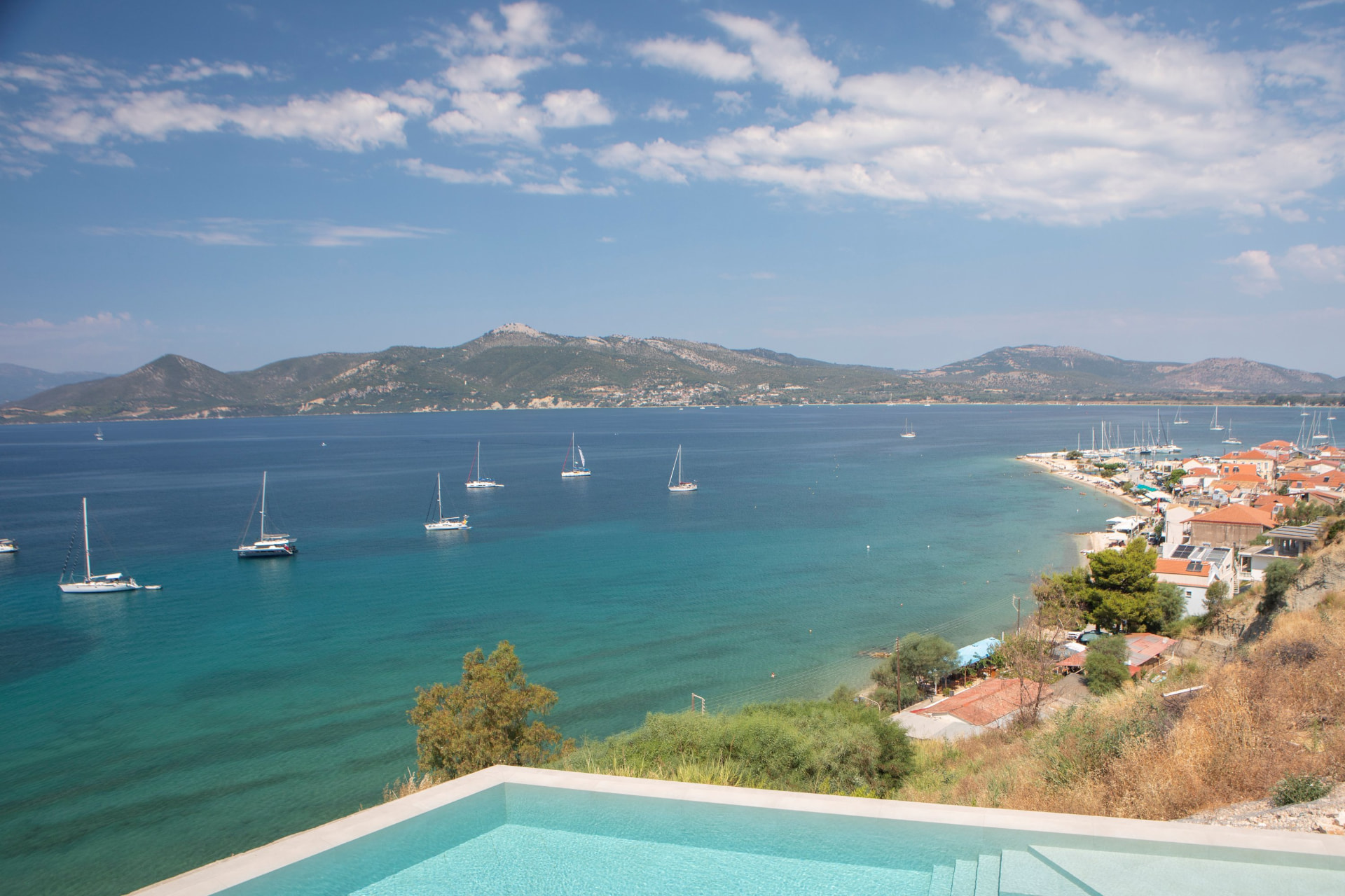 Turquoise bay of Paleros with sailing boats seen from the infinity pool