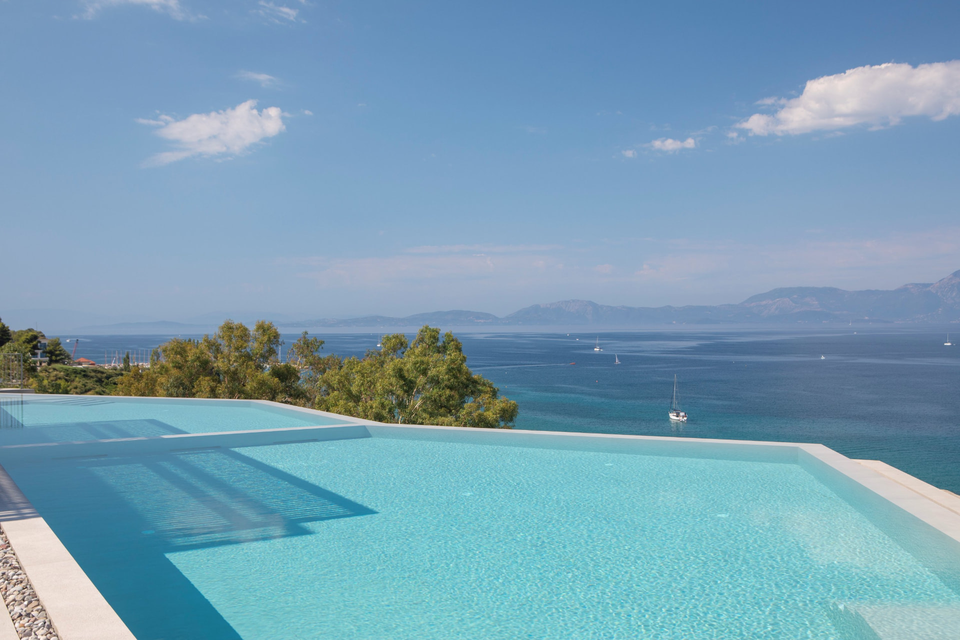 Twin infinity pools looking out over the turquoise Ionian sea