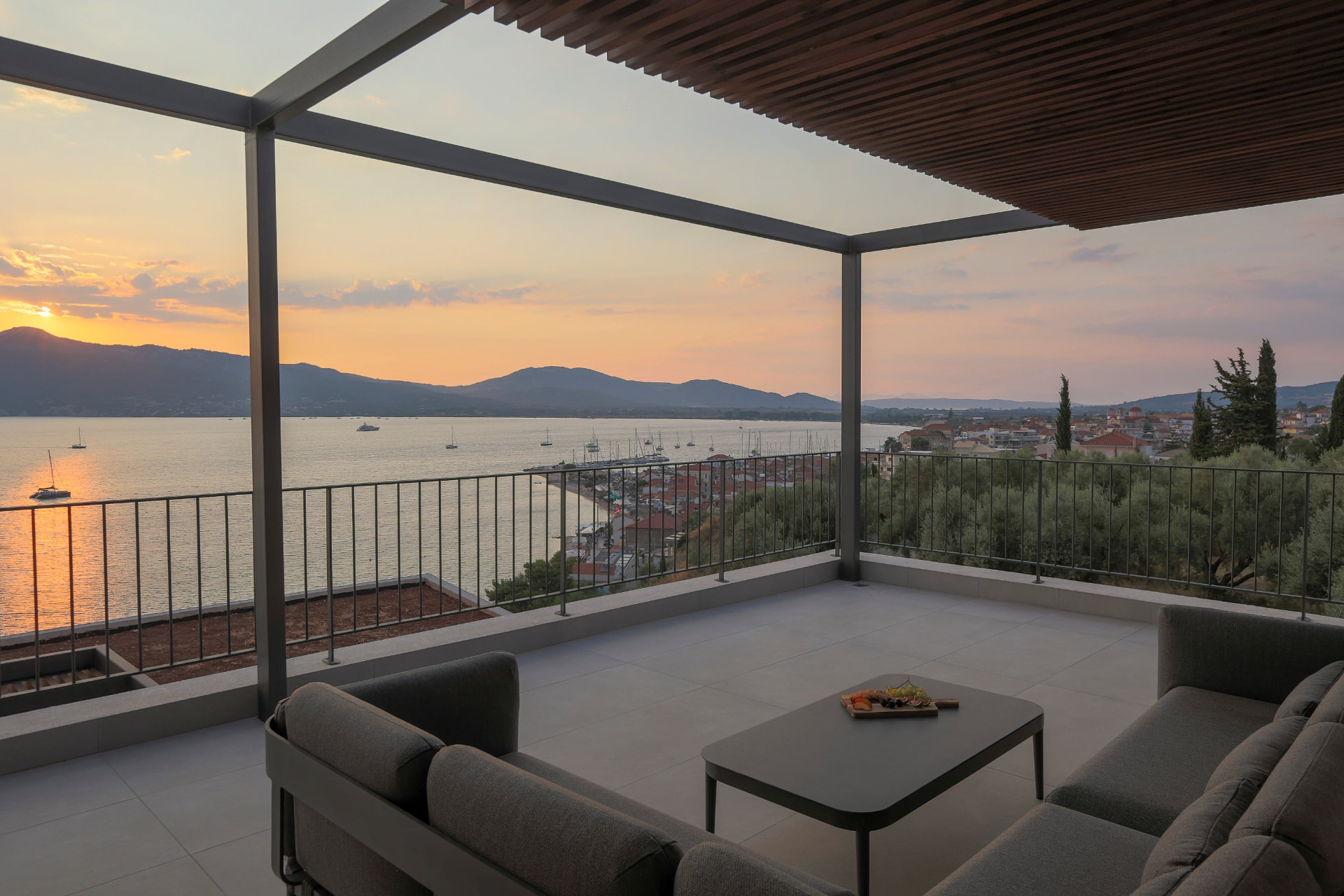 Upper terrace lounge at sunset overlooking Paleros marina and the bay