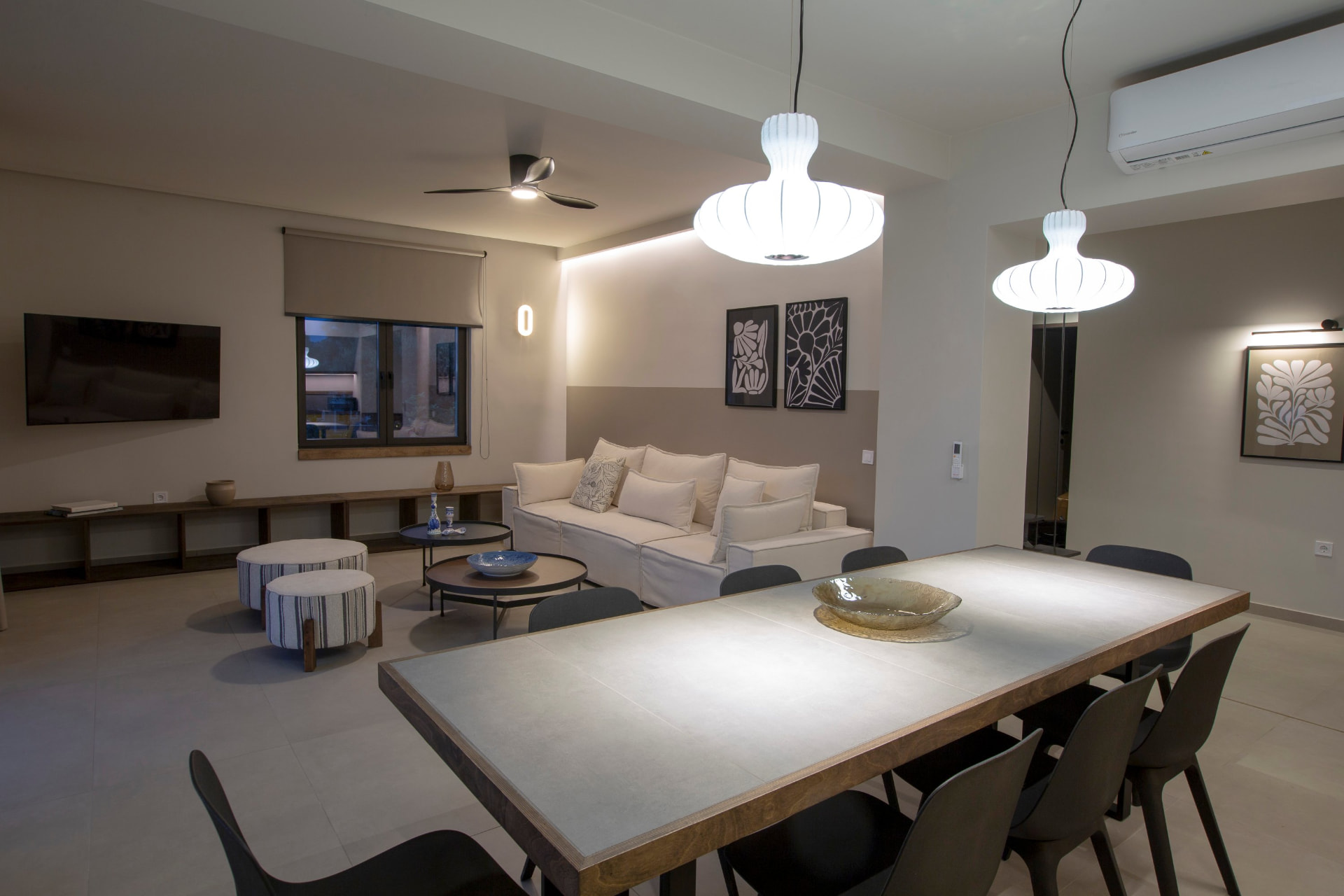 Open plan living and dining area with pendant lighting and linen sofa